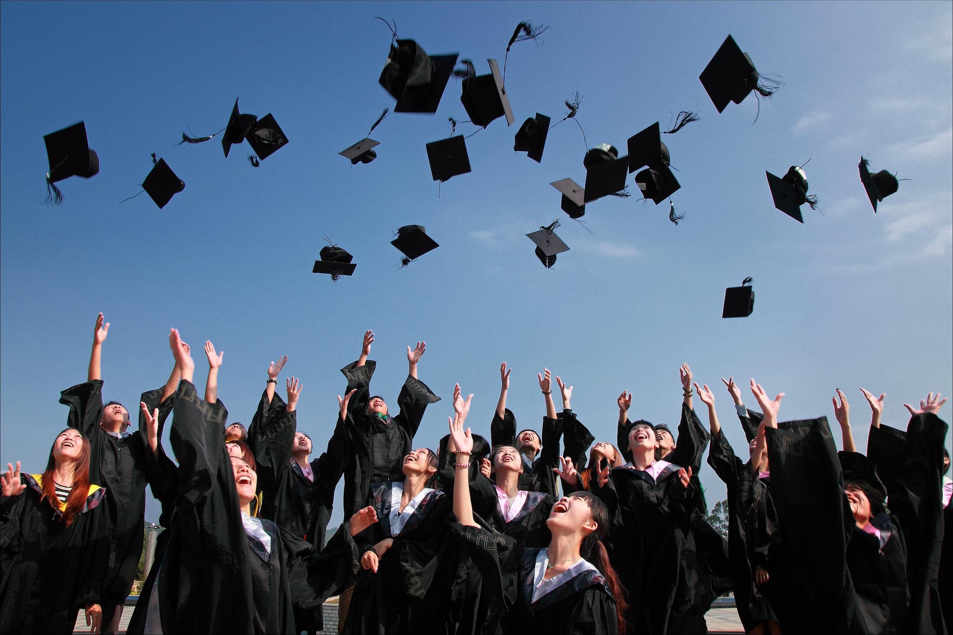 graduate students flying caps